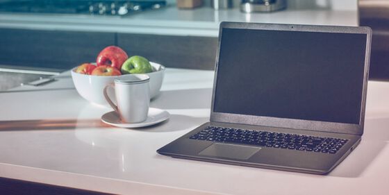 A laptop computer and IQOS device on a table.