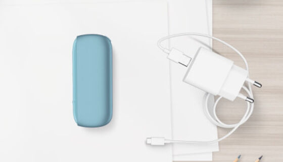 Turquoise IQOS ORIGINALS DUO pocket charger next to cable charger.