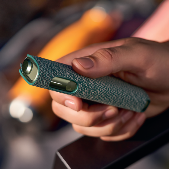An IQOS ILUMA device and mobile phone.