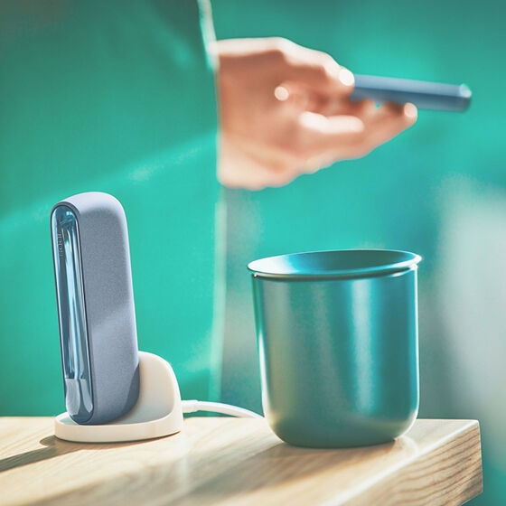 A person with an IQOS ILUMA Pocket Charger and Holder.