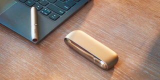 Blond girl with her gold IQOS kit in her hands
